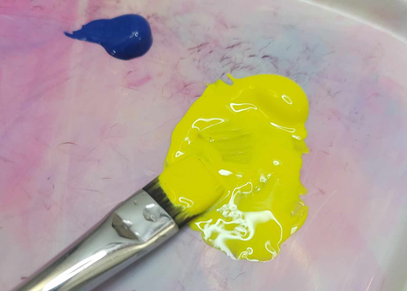 Photo of a brush mixing paint on a palette